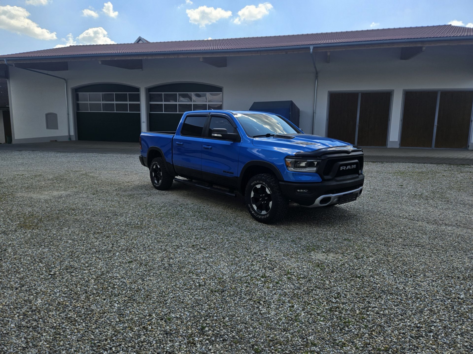 RAM 1500 Rebel Crew Cab 4x4 in Hydro Blue Pearl – Frontansicht schräg, Off-Road-Pickup mit 5,7-l-HEMI der Gen 5