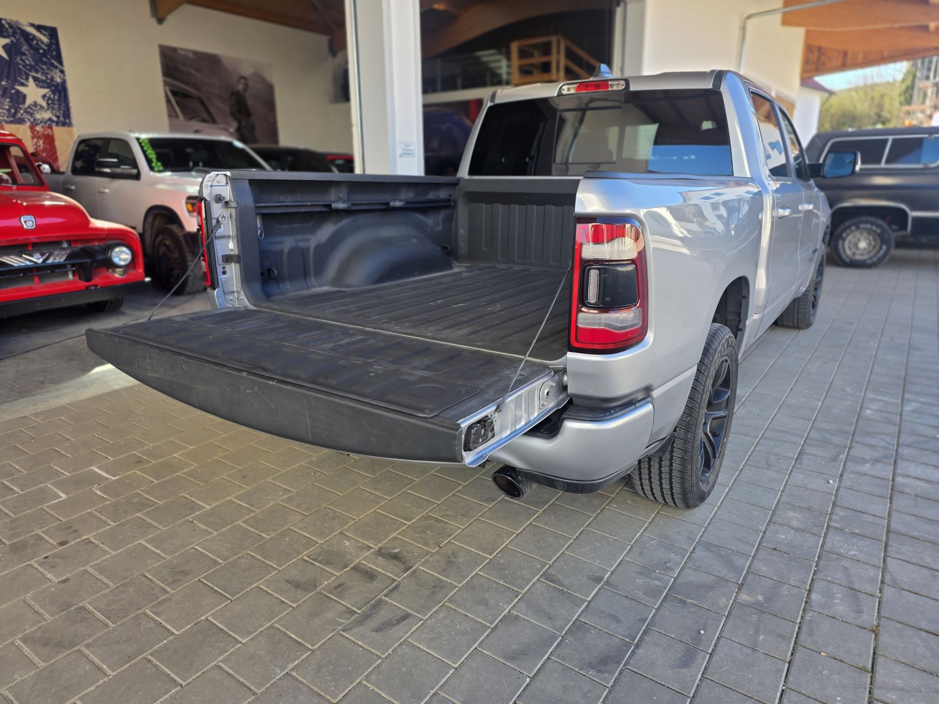Ladefläche des RAM 1500 mit geöffneter, gedämpfter Heckklappe – Spray-in-Bedliner und schwarzes Auspuffendrohr sichtbar