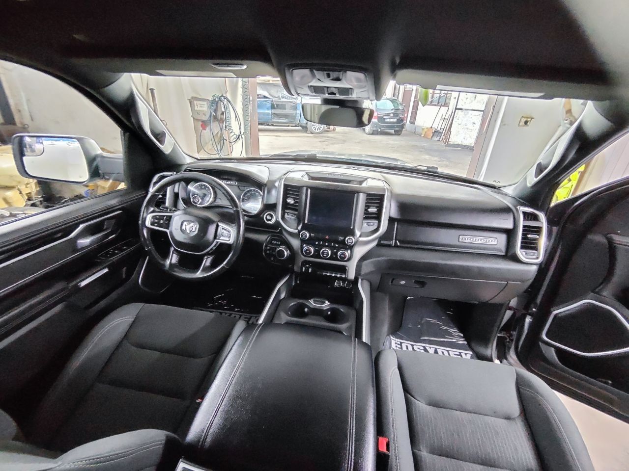 Innenraum der RAM 1500 Big Horn Night Edition – Armaturenbrett, schwarze Stoffsitze und durchgehende Mittelkonsole