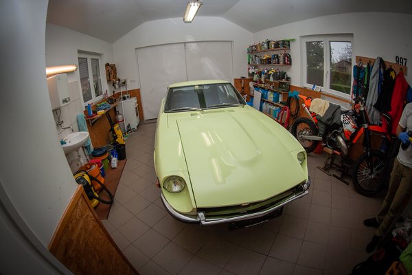 Engine bay of a 1972 Datsun 240Z being cleaned and detailed with the bonnet raised