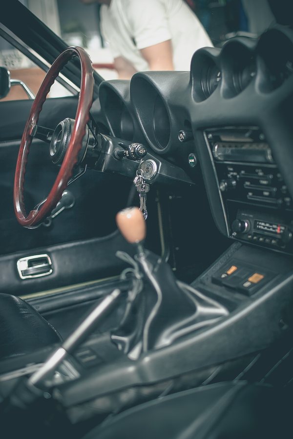 Interior of a 1972 Datsun 240Z showing the dashboard, centre gauges and wood-rimmed steering wheel