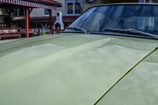 Machine polishing the Lime Yellow paintwork of a 1972 Datsun 240Z during paint correction