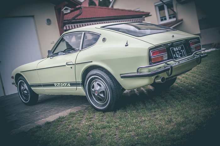Lime Yellow Datsun 240Z parked outdoors, rear three-quarter with chrome bumper and alloy wheels