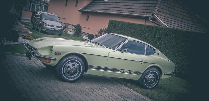 Lime Yellow Datsun 240Z seen from the side on a paved driveway