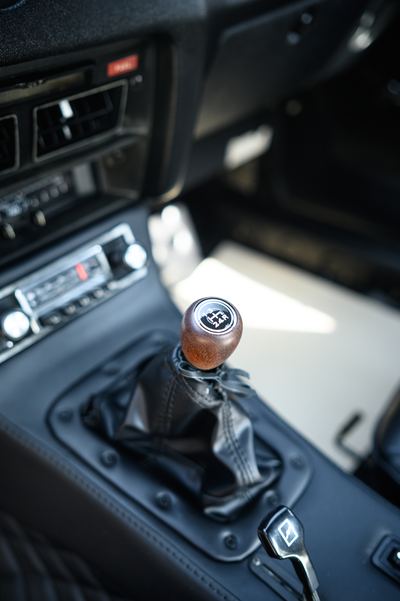 Wood-topped gear lever and centre console inside a Datsun 280Z
