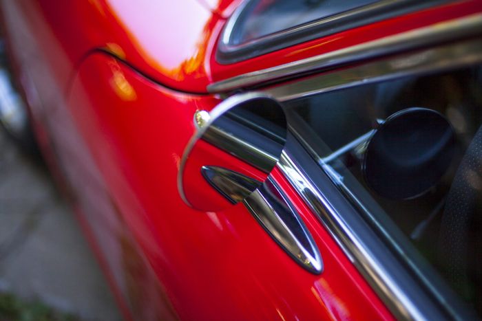 Chrome door handle set into the red bodywork of a Datsun 280Z