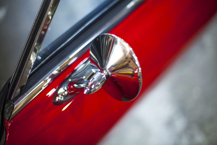 Wing mirror and red door of a Datsun 280Z
