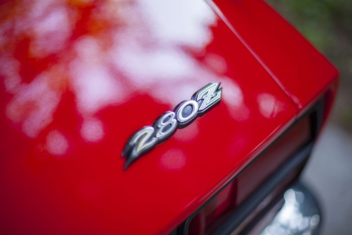 Chrome 280Z script badge on the red rear panel of a Datsun 280Z