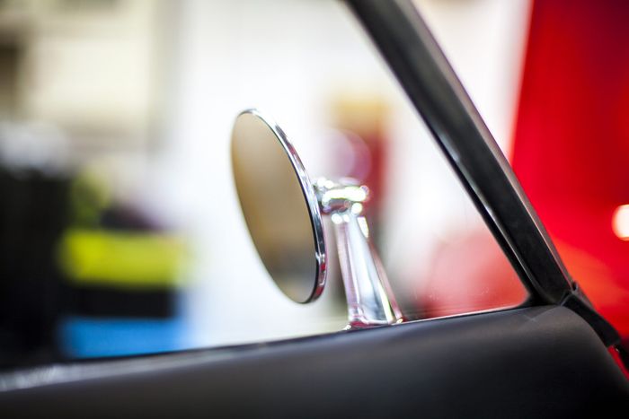 Period aftermarket chrome bullet wing mirror fitted to a red Datsun 280Z