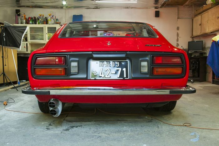Rear of a red Datsun 280Z with Japanese registration plate and tail light panel