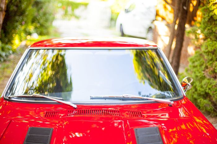 Windscreen and twin bonnet vents of a red Datsun 280Z seen from the front