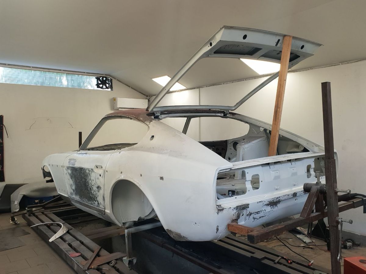 Datsun 280Z shell on the jig during metalwork — original panels repaired, classic Datsun Z restoration