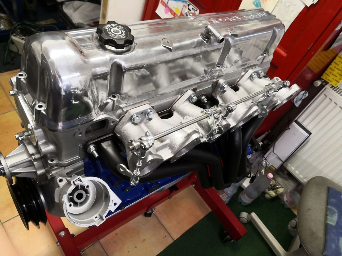 Datsun 280Z L-series engine build — intake manifolds and black tubular headers fitted