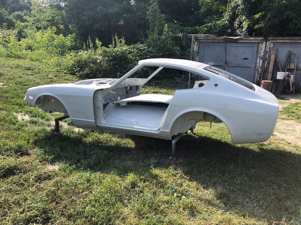 Datsun 280Z shell media blasted to bare metal — full side profile before rust repair, S30 restoration
