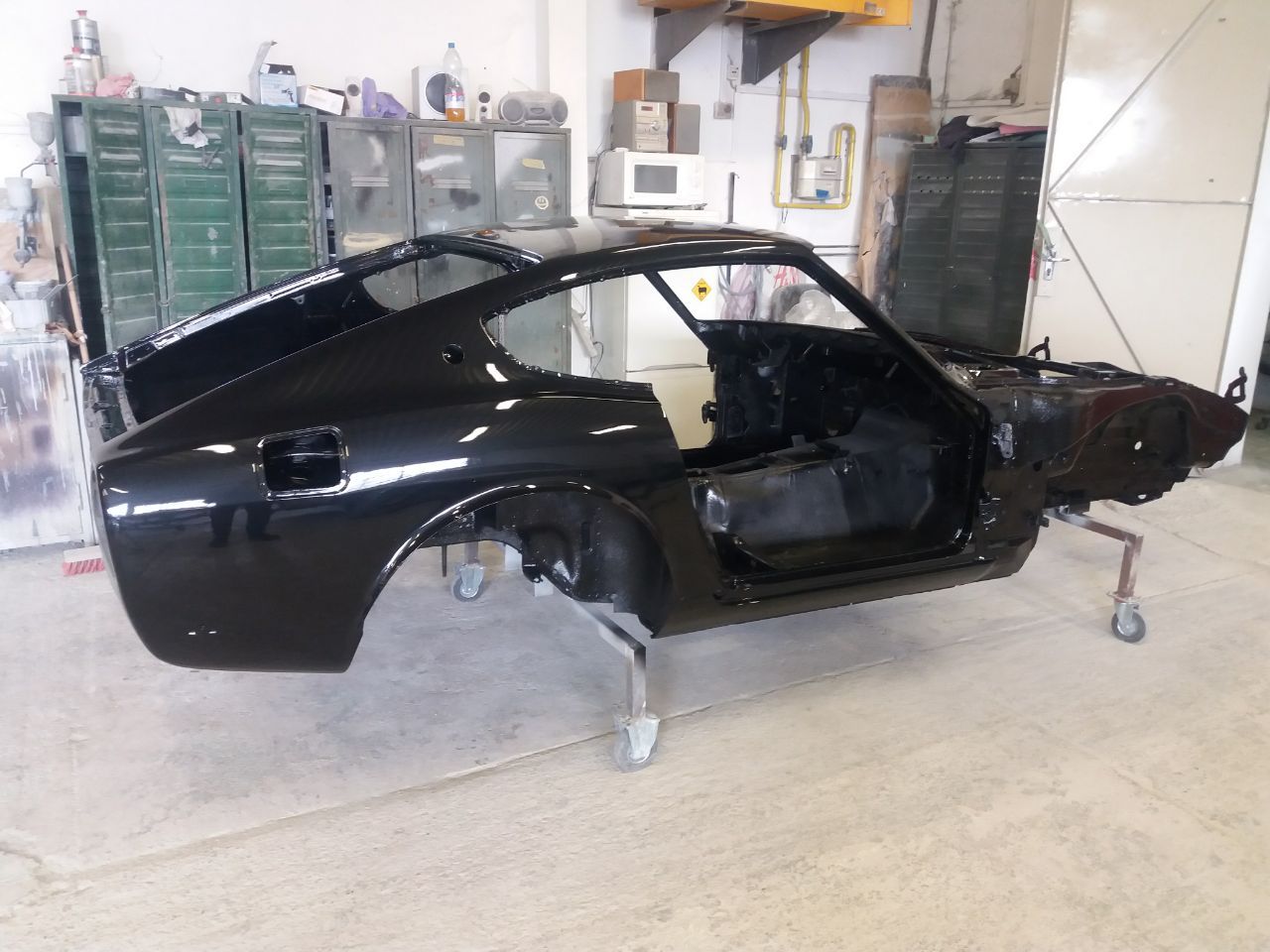 Freshly painted black Datsun 280Z body shell — restored classic Datsun Z in deep gloss black
