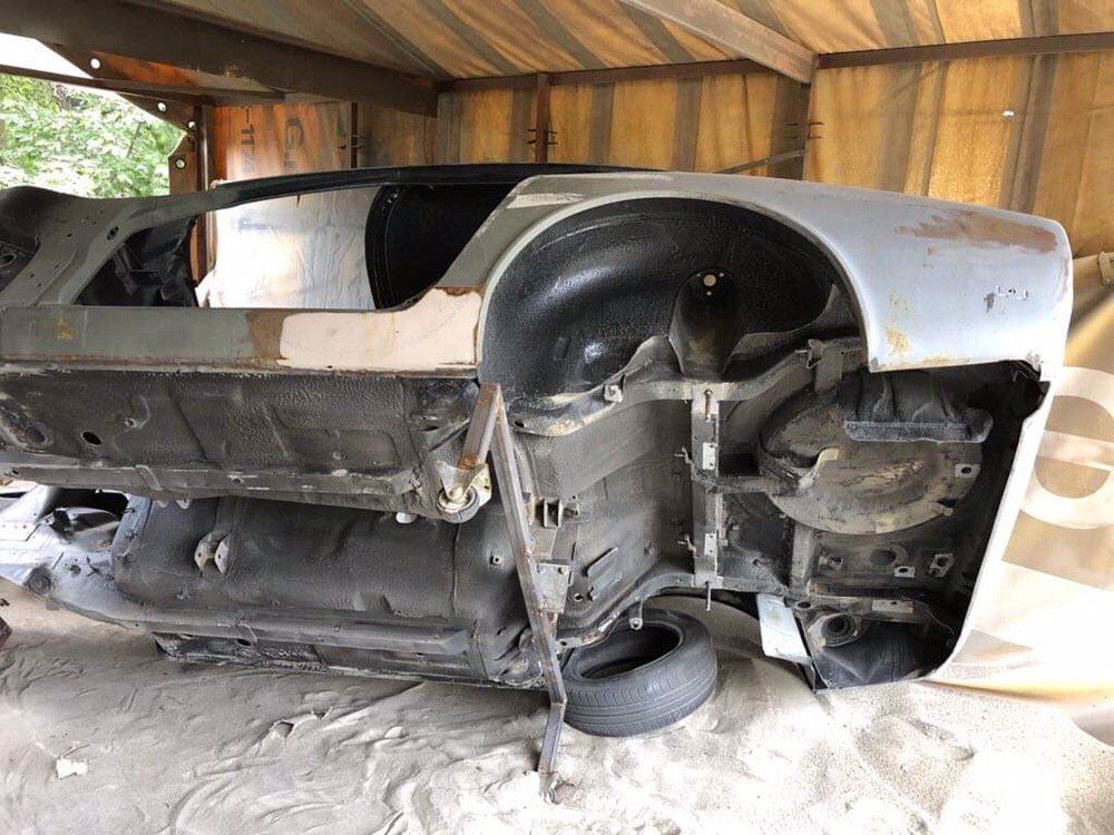Underside of a media-blasted Datsun 280Z shell — rust removed from floor pans and wheel arches