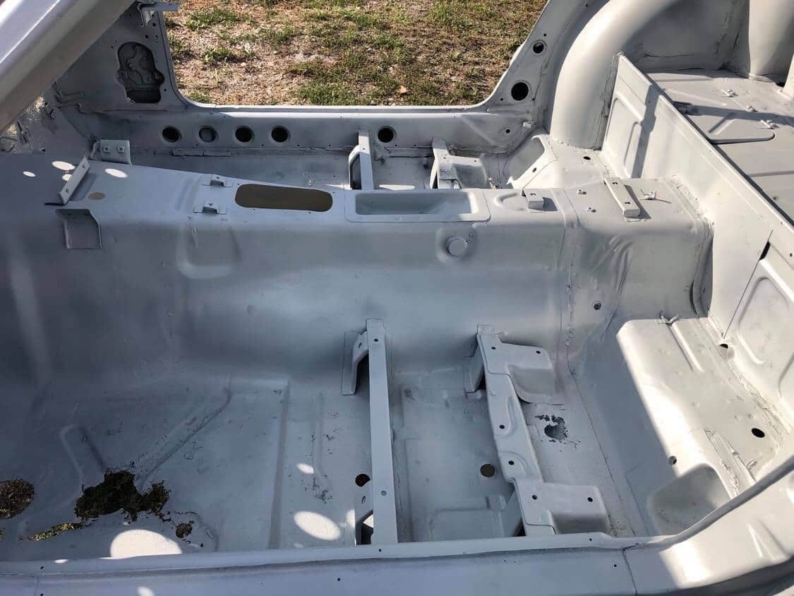 Media blasted Datsun 280Z wheel tub and inner panel revealing rust holes through the metal