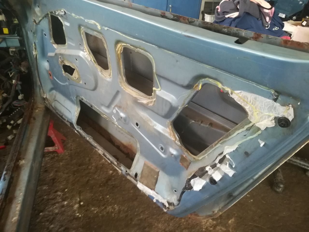 Bare floorpan of the Datsun 280Z showing surface rust and seam corrosion after the interior was stripped
