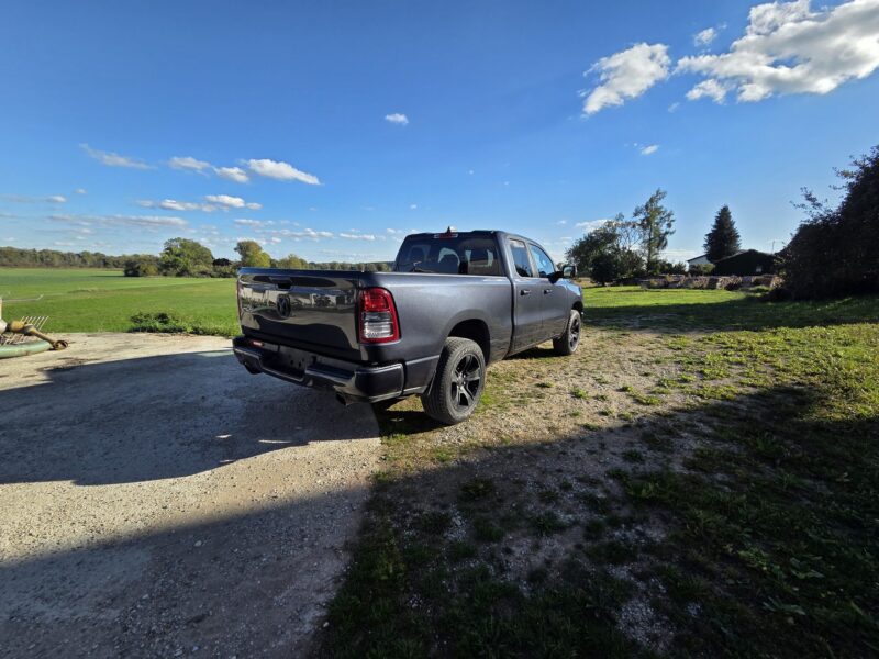 ram-1500-big-horn-2021-4x4-quad-cab-hinten-links-40 RAM 1500 Big Horn 2021 Quad Cab 4x4 Pick-up von hinten links im Grünen