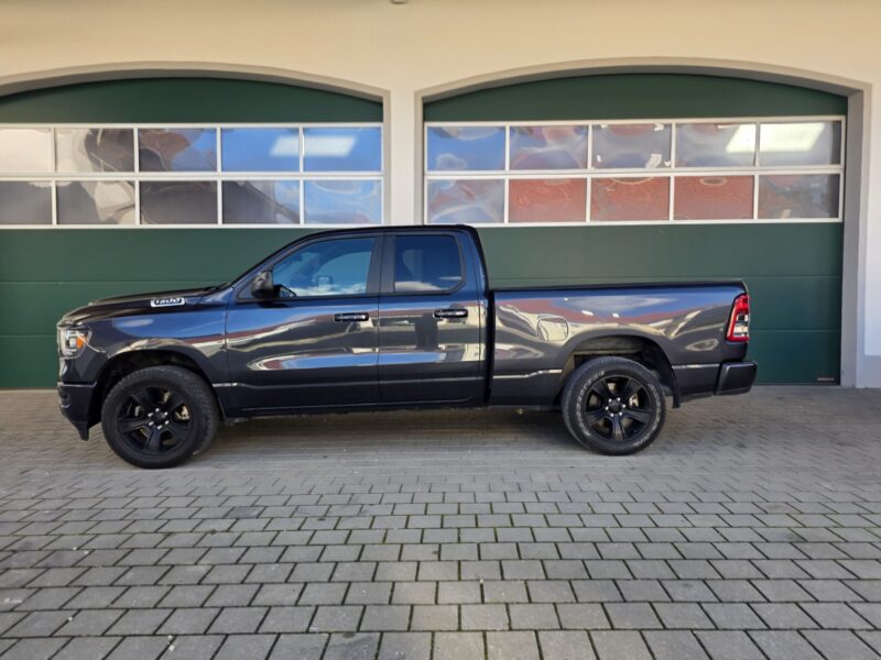 RAM 1500 Big Horn 2021 Quad Cab 4x4 Quad Cab Seitenprofil links vor grünem Tor