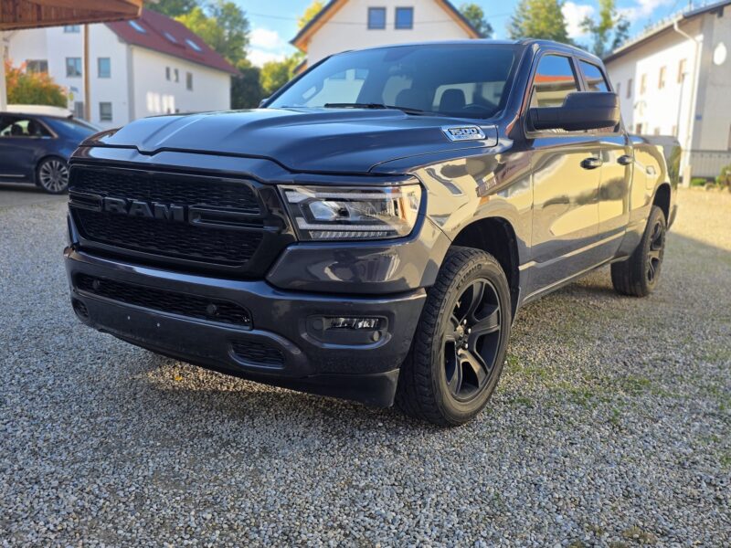 RAM 1500 Big Horn 2021 Quad Cab 4x4 in Maximum Steel Metallic, vorne links mit schwarzen 20-Zoll-Felgen