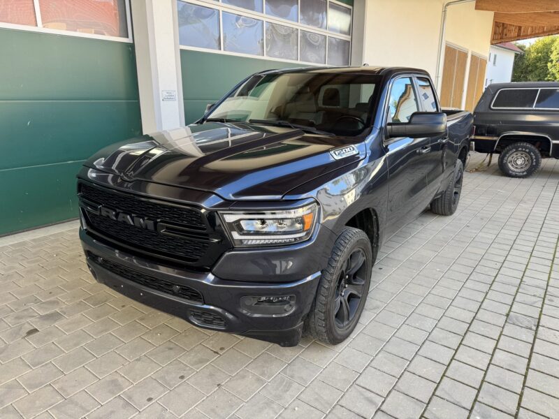 RAM 1500 Big Horn 2021 Quad Cab 4x4 in Maximum Steel Metallic mit schwarzem Kühlergrill und schwarzen Felgen, Frontansicht schräg rechts