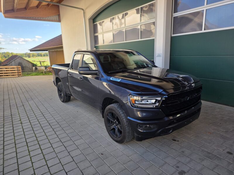 RAM 1500 Big Horn 2021 Quad Cab 4x4 in Dunkelgrau Metallic, Seitenansicht vorne rechts